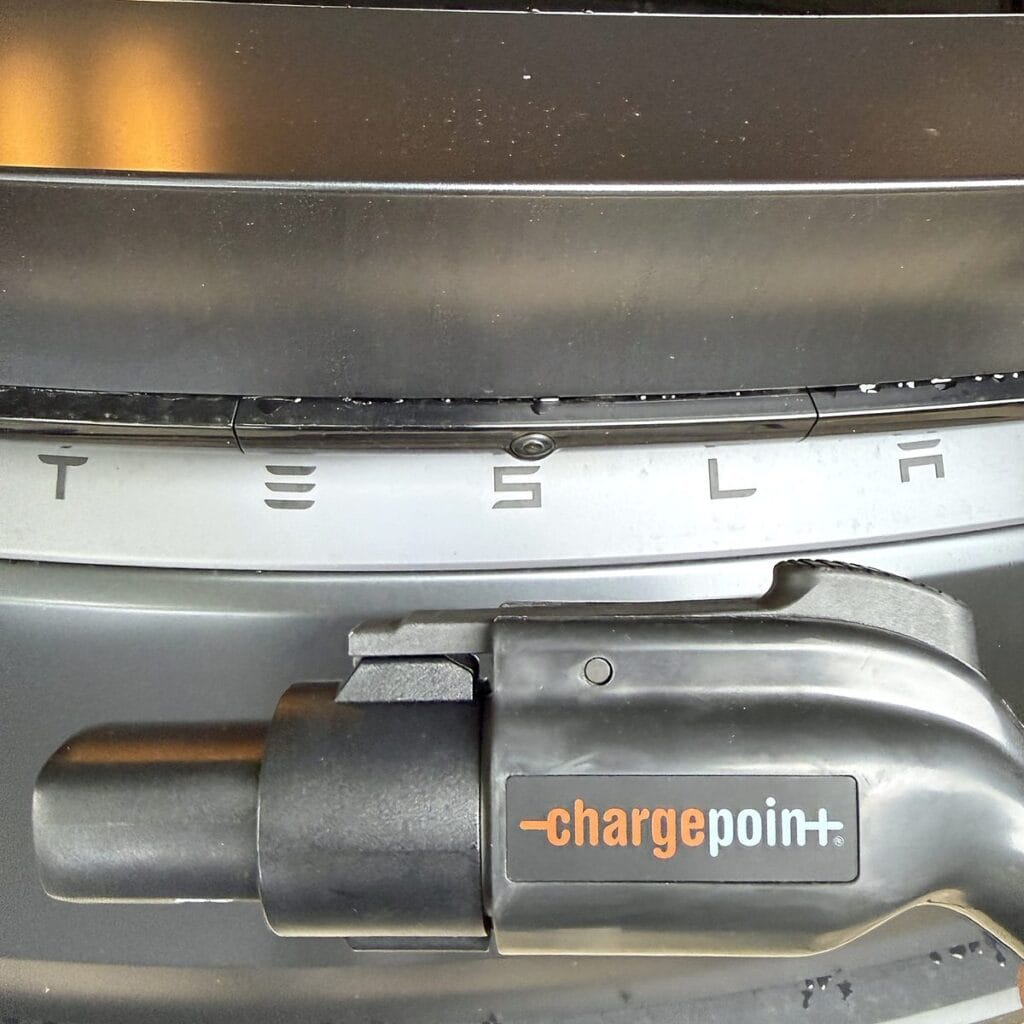 ChargePoint Home Flex J1772 connector with the Tesla J1772 adapter attached, plugged into a Tesla Model Y
