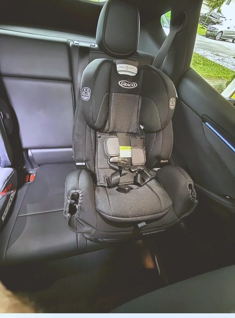 Graco 4Ever Extend2Fit installed forward-facing in the rear seat of a Tesla Model Y