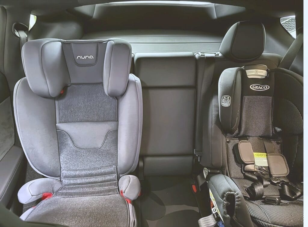 Graco 4Ever Extend2Fit next to a Nuna Aace booster in a Tesla Model Y