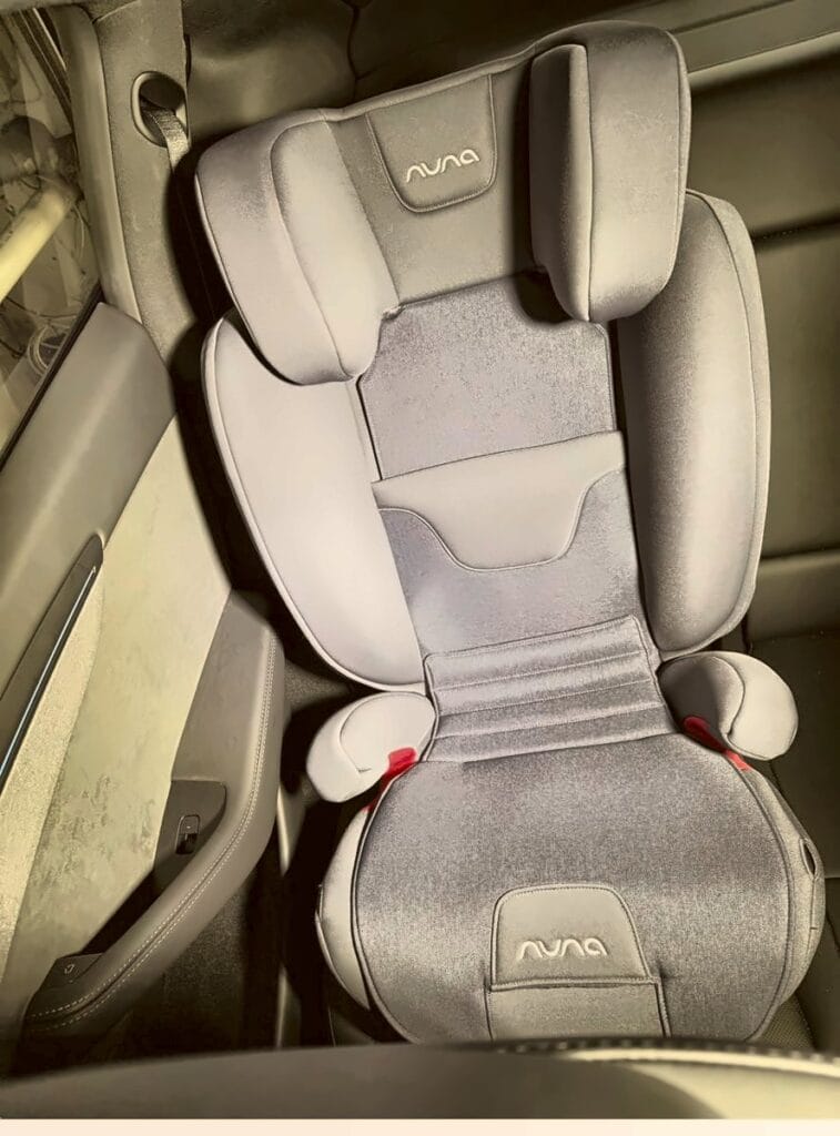 Nuna Aace high-back booster installed in the rear seat of a Tesla Model Y