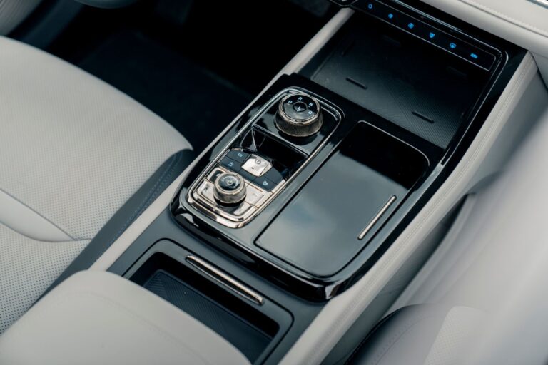 Close-up of a sleek modern car center console with controls and storage compartments