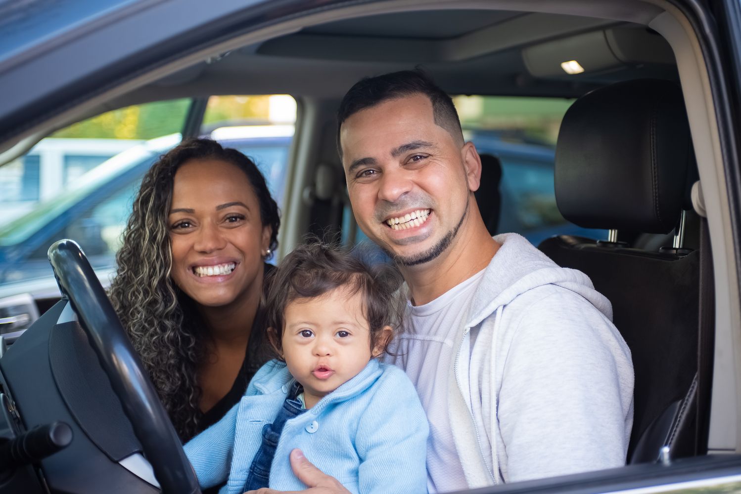 Family smiling together in a car, representing a Tesla Model Y family road trip
