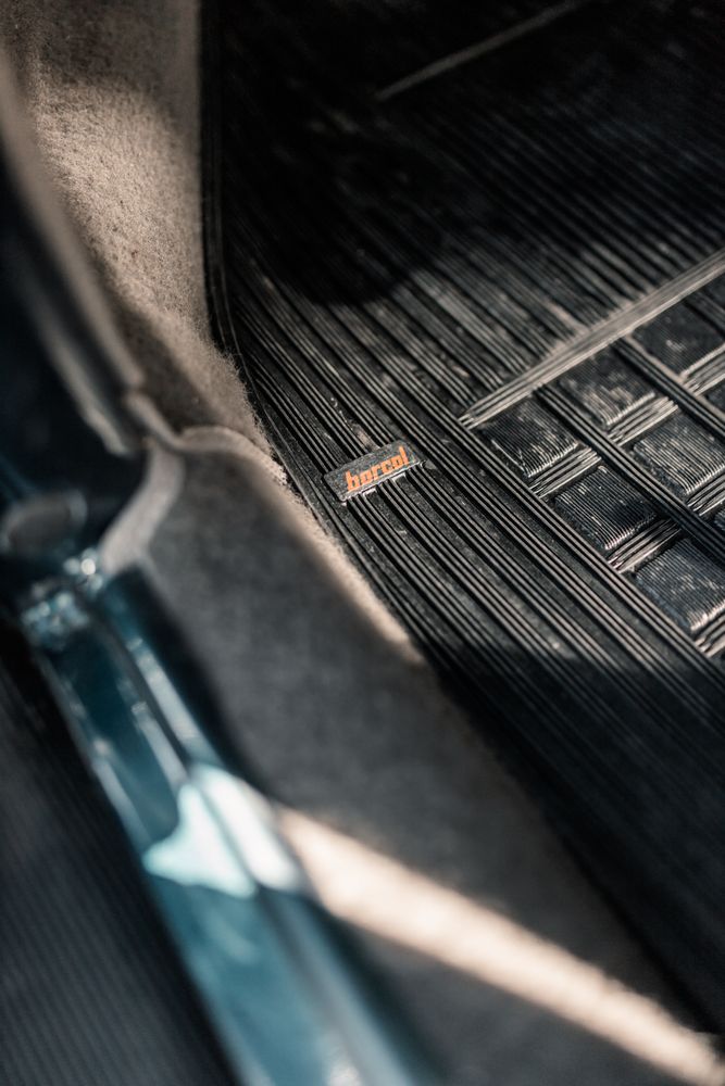 Detailed view of a car floor mat with light and shadow play, focusing on texture and design