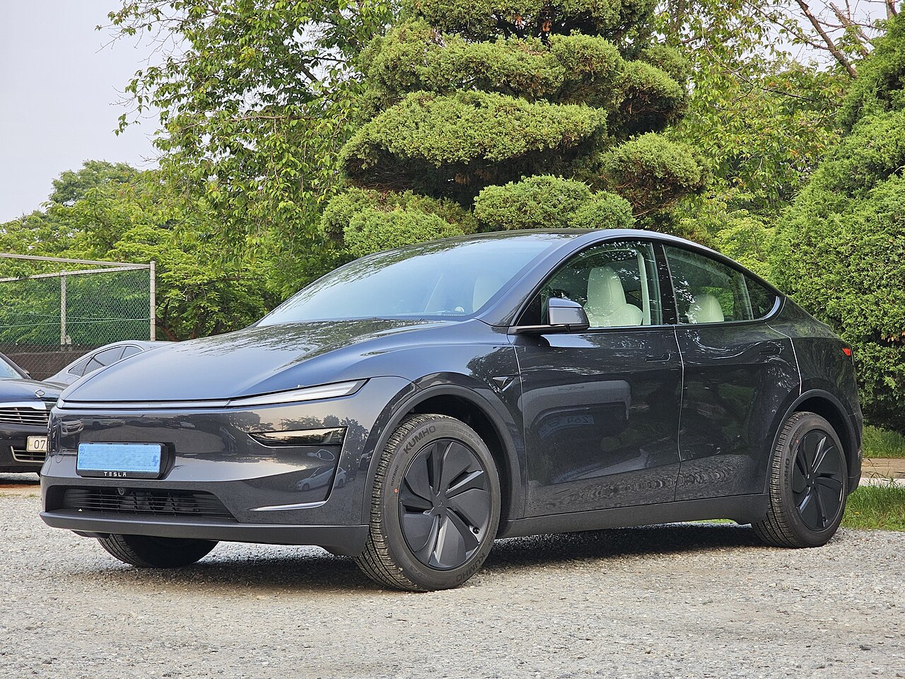 Stealth Grey Tesla Model Y (Juniper refresh) parked outdoors, three-quarter front view