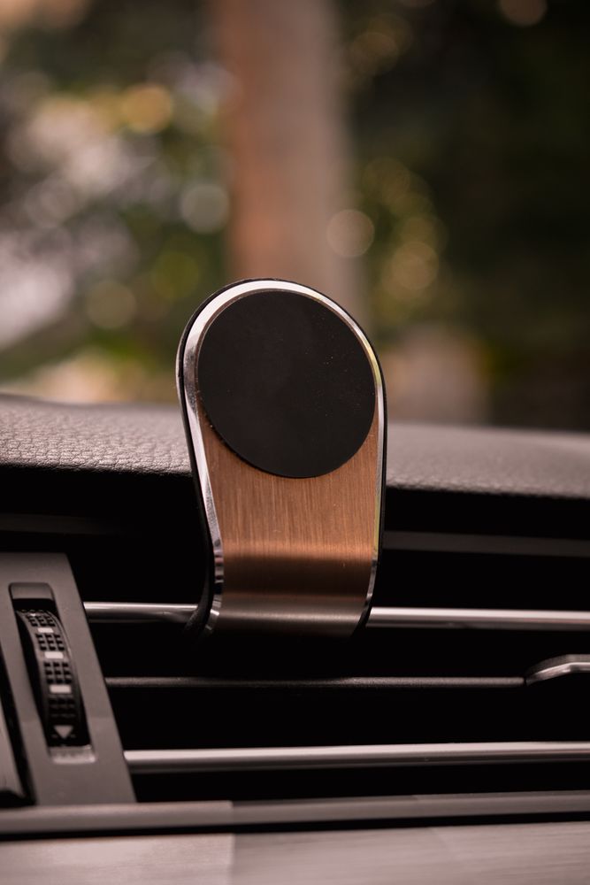 Close-up of a metallic magnetic phone holder mounted on a car air vent