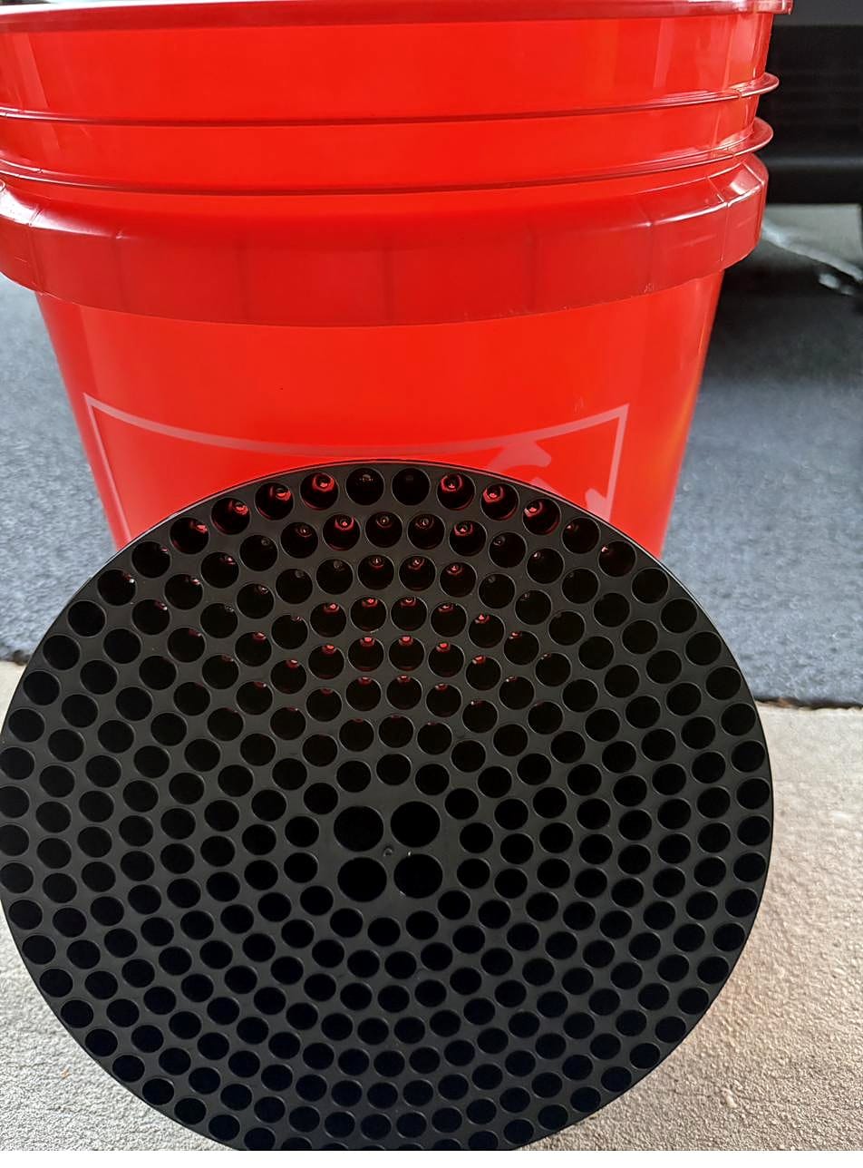 Dirt trap insert at the bottom of a red wash bucket