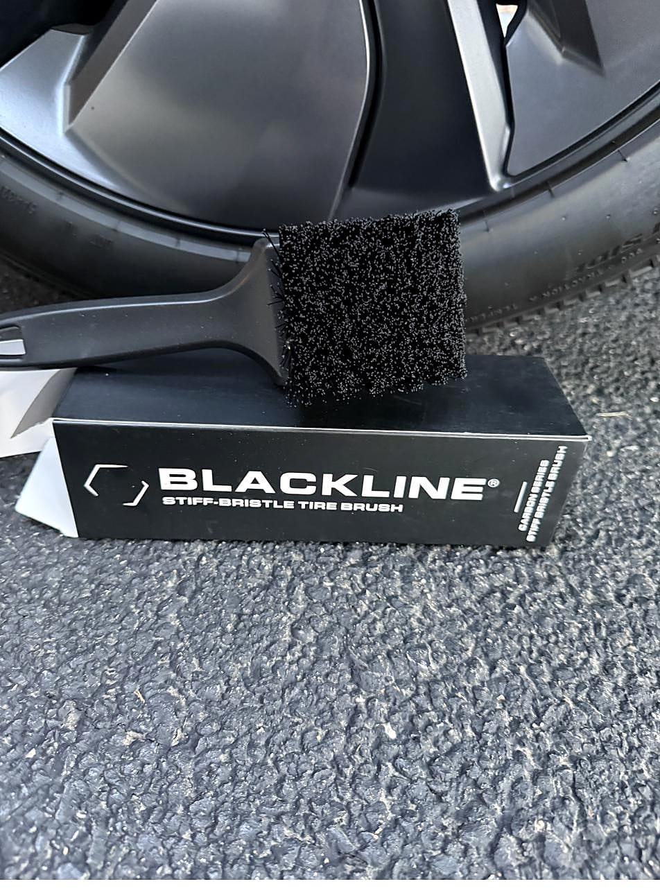 Blackline stiff-bristle tire brush on a Tesla Model Y wheel