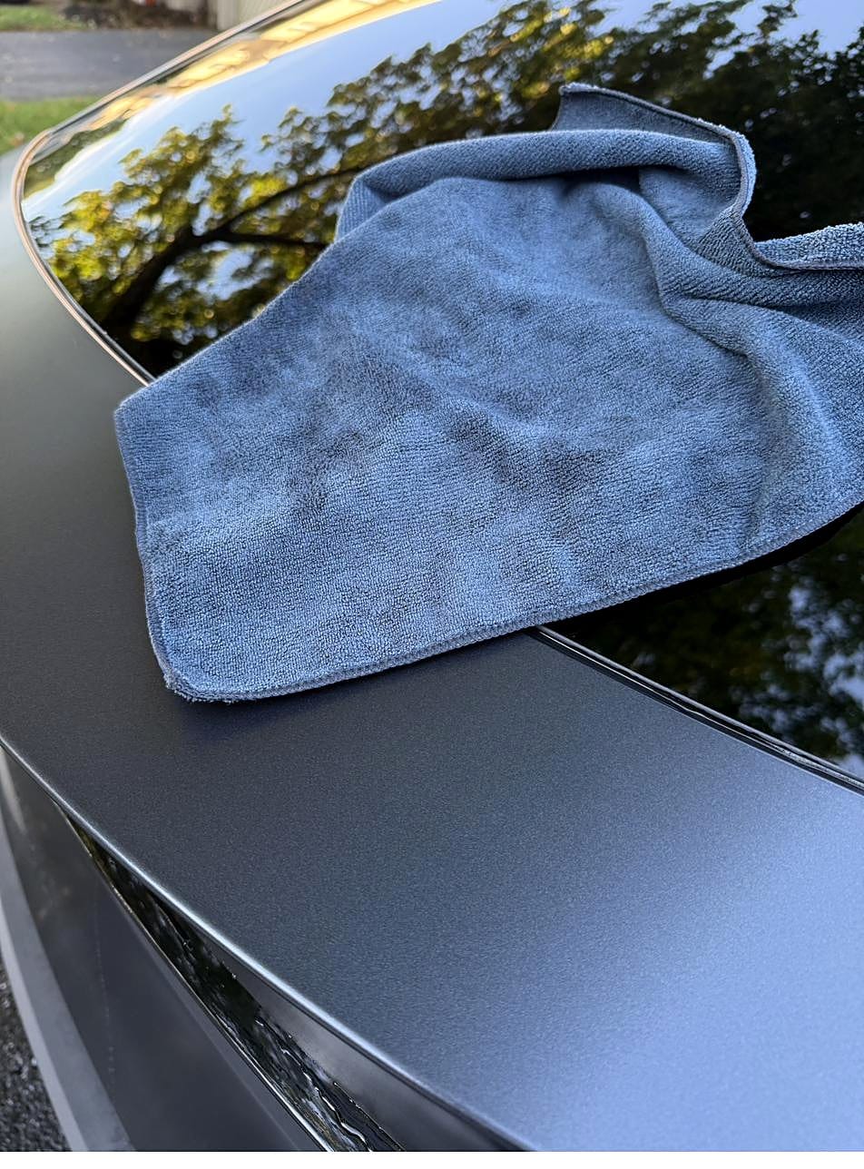 Blue microfiber towel on a Tesla Model Y hood