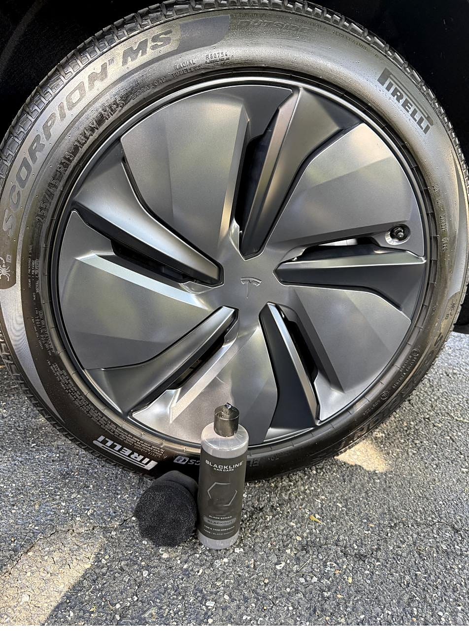 Blackline Blackout tire dressing and applicator by a Tesla Model Y tire